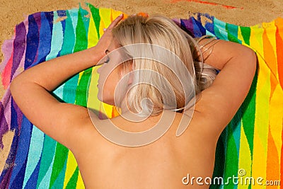 Blond woman sunbathing topless Stock Photo