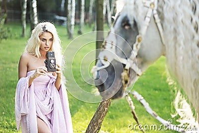 Blond woman taking photos with retro camera Stock Photo