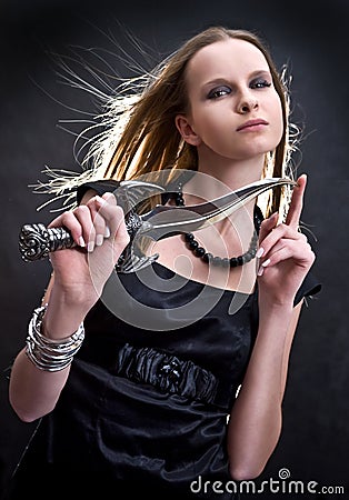 Blond young girl holding dagger Stock Photo