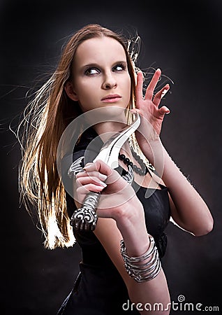 Blond young girl holding dagger Stock Photo