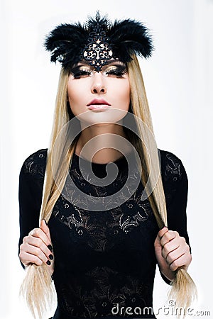 Portrait of Stylized Woman Blonde in Black Carnival Mask with Feathers. Holiday Stock Photo