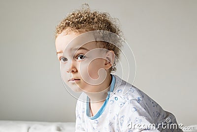 Blonde boy in bright pajamas on the white carpet Stock Photo