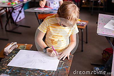 Blonde boy with glasses drawing. Group of elementary school pupils in classroom on art class. Russia, Krasnodar, May, 23, 2019 Stock Photo