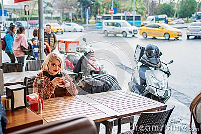 Blonde in a cafe drinking hot tea Editorial Stock Photo