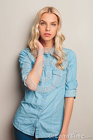 Blonde casual woman hold hand on neck Stock Photo