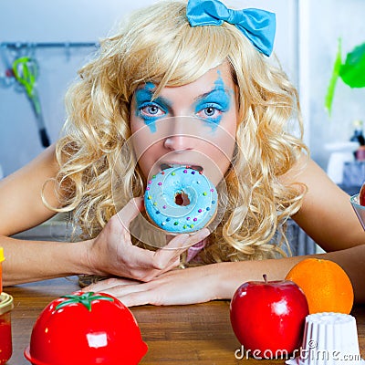 Blonde funny girl on kitchen eating blue dona Stock Photo