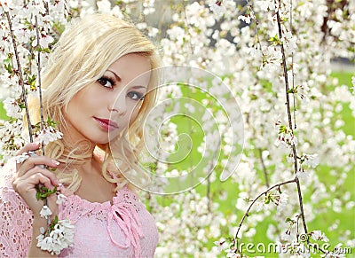 Blonde Girl with Cherry Blossom. Spring Portrait. Stock Photo