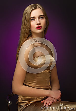 Blonde girl in gold. Classic portrait. Blue eyes and red lips. Chic Stock Photo