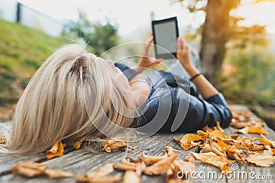 Blonde girl reads a book from her ebooks readers Stock Photo