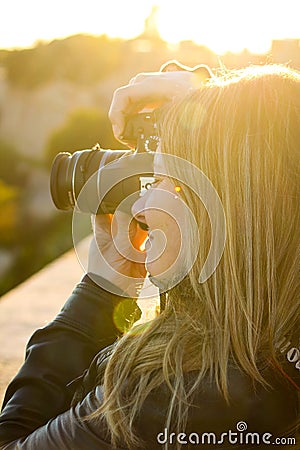 Blonde girl takes photos with reflex Stock Photo