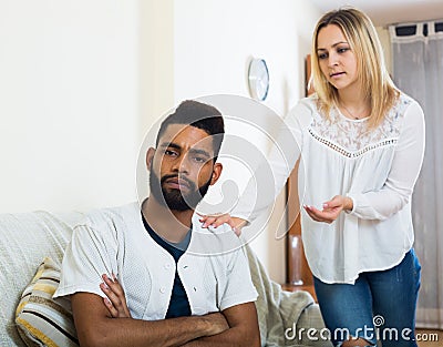 Blonde girl yelling at black boyfriend as quarreling indoors Stock Photo