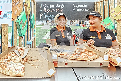 Blonde girls sell pizza in a small summer cafe Editorial Stock Photo