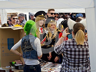 Blonde girls in uniform among near kiosk with souvenirs at the japanese animation festival Editorial Stock Photo