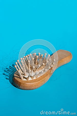 Blonde hair loss problem with hairbrush on blue background. Alopecia, hair problem, falling hair on brush healthy Stock Photo