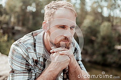 Blonde-haired man feeling unsure about making serious life changing decision Stock Photo