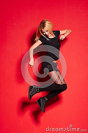 Blonde lady in black posing on red Stock Photo