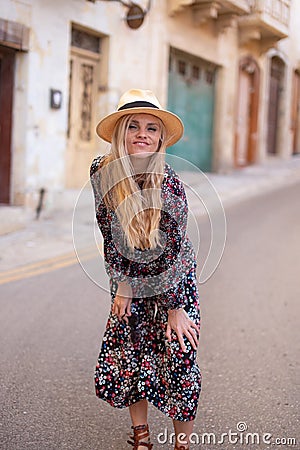 Blonde Mediterranean 20s woman floral pattern dress posing Stock Photo