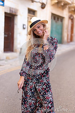 Blonde Mediterranean woman floral pattern dress posing Stock Photo