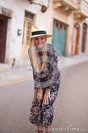 Blonde Mediterranean woman floral pattern dress posing at Valletta Stock Photo
