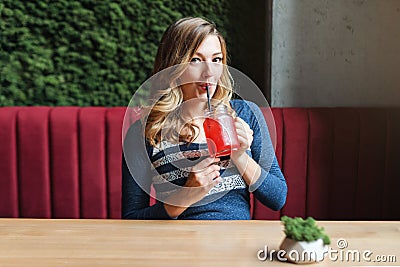 Blonde pretty woman drinking lemonade in cafe Stock Photo