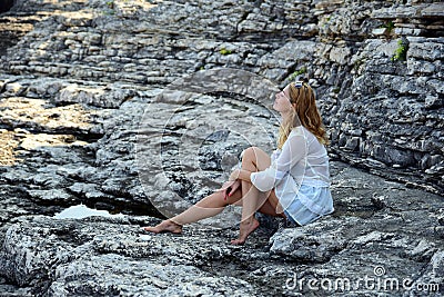 Blonde on rocky beach Stock Photo