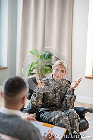 Blonde servicewoman explaining her anxiety to psychologist Stock Photo