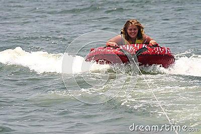 Blonde teenager being pulled on a inner tube raft Stock Photo