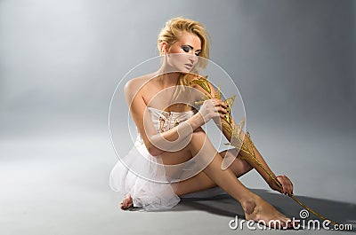Blonde in white dress holding golden calla lilly Stock Photo