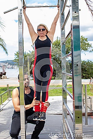 Blonde lady exercising with her personal trainer Stock Photo