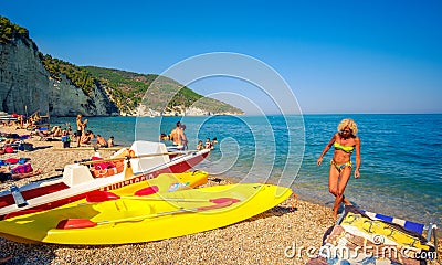 Blonde woman come out of the sea water in the Vignanotica beach, one of the top beaches in Apulia Editorial Stock Photo