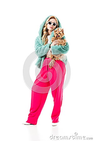 Blonde woman in fur coat holding cute Yorkie Stock Photo