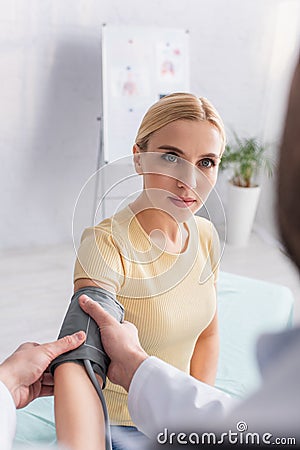 blonde woman looking at blurred doctor Stock Photo
