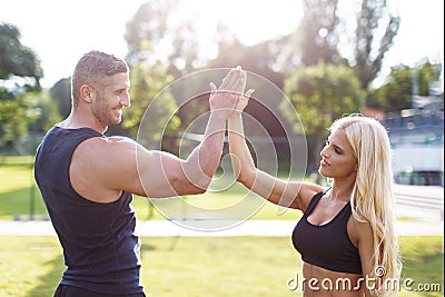 Blonde woman with personal trainer give high five Stock Photo