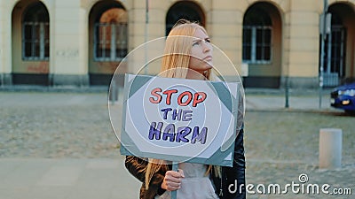 Blonde woman protesting to stop harm by holding steamer Stock Photo