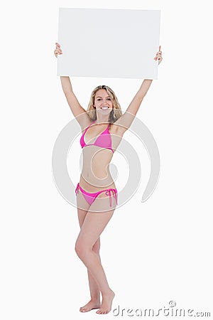 Blonde woman raising a blank poster above her head Stock Photo