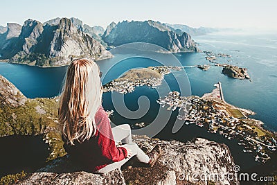 Blonde woman relaxing on cliff mountain top traveling Stock Photo