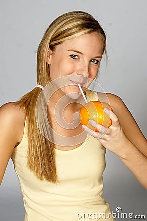 Blonde Woman Sipping Juice from Orange Stock Photo