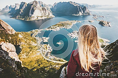 Blonde woman on the top of Reinebringen mountain fjord aerial view Stock Photo