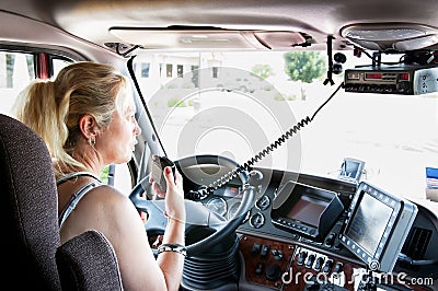 Blonde woman truck driver talking on her radio. Stock Photo