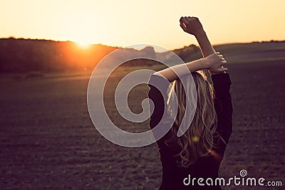 Blonde woman watching sunset Stock Photo