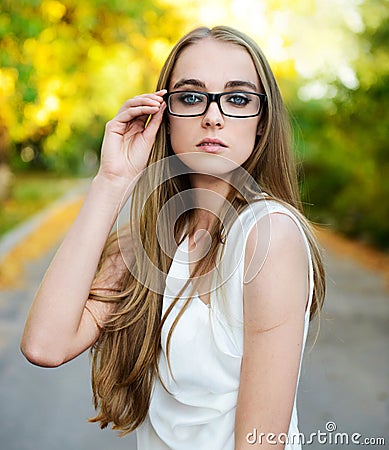 Blonde woman wearing eyeglasses and white blouse Stock Photo