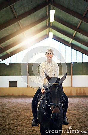 Blondeï¿½confident female sitting astride dark horse Stock Photo
