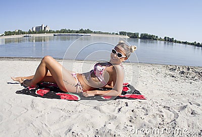 Blondy beautiful and very handsome girl posing on the beach during the summer. Stock Photo