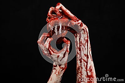 Blood and Halloween theme: terrible bloody hand hold torn bleeding human heart isolated on black background in studio Stock Photo