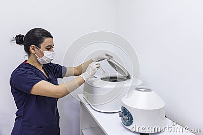 The blood tube is removed from the medical centrifuge for plasma lifting. Prp procedure. Cosmetology and skin care. Platelet-Rich Stock Photo