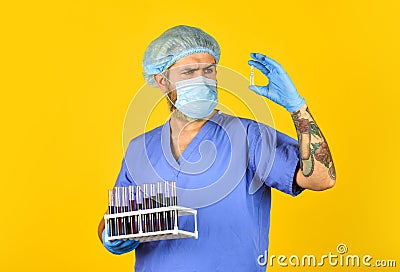 Blood virus test. doctor wearing surgical mask while testing. nurse examines blood samples in lab. antibody for SARS can Stock Photo