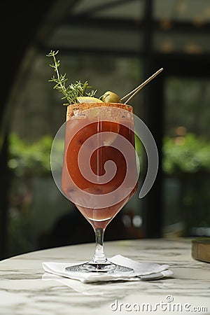 Bloody Mary cocktail glass with olive, lemon slice and ice cubes Stock Photo