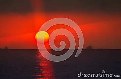 Bloody sun between sea and cloud Stock Photo
