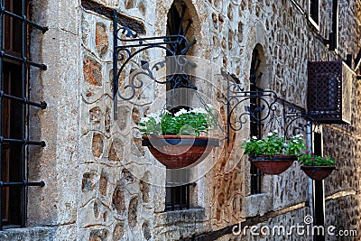 Blooming flowers in a flower pot hanging from the wall near the window in the historical part of Antalya known as Kaleici. Turkey. Stock Photo