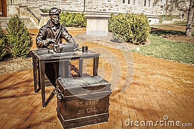 Bloomington USA Bronze statue of historic US miliary man with typewriter and Army chest and google sitting in on campus Editorial Stock Photo